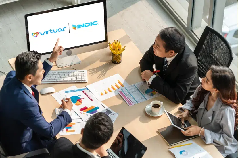Graphic design workspace with laptop showing brand identity design, color palette, and design tools on wooden desk